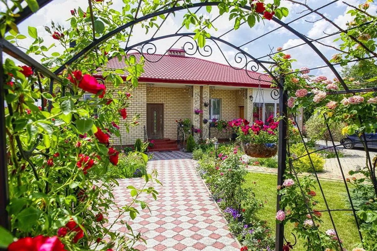 Дом в окружении зелени и цветов.